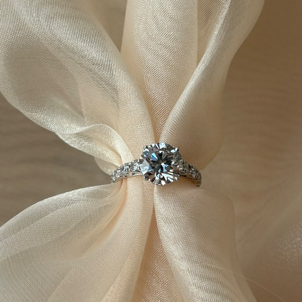 Anel solitário com diamante sobre tecido de organza