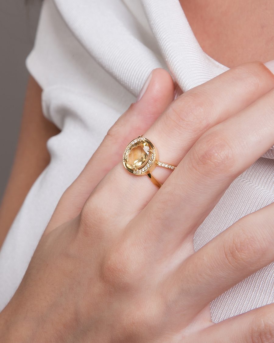 Detalhe de anel dourado com pedra citrina